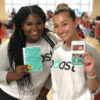 two females holding boost branded collateral